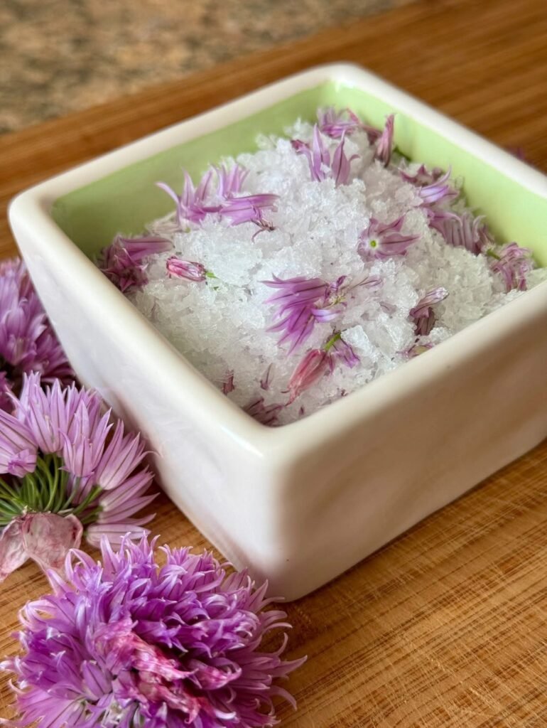 homemade chive flower salt from garden herbs in wooden bowl